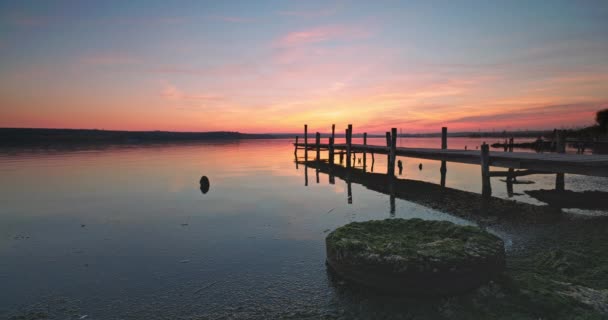 海の湖と古い木製の桟橋の上の夕日 — ストック動画