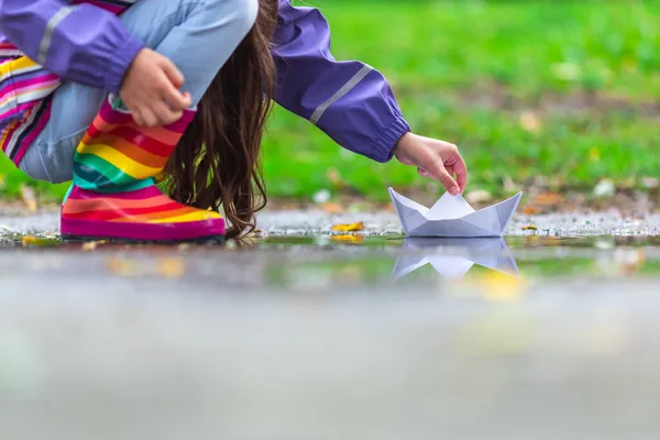 Счастливая Девочка Красочных Резиновых Сапогах Играет Бумажной Лодкой Луже Осенью — стоковое фото