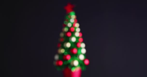ボールと輝く星で飾られたクリスマスツリーは黒の背景で回転します — ストック動画
