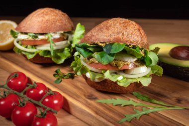 Sağlıklı Vegan Burger. Hamburgerler ahşap masada ve sebzelerde