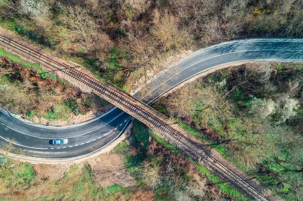 从空中俯瞰一座桥上的铁路轨道和美丽的森林 道路景观及驾驶车辆 — 图库照片