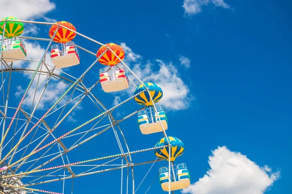 Mavi gökyüzü ve bulutlu dönme dolap