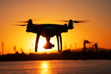 Uçan Drone ve günbatımı deniz suyu üzerinde gökyüzü