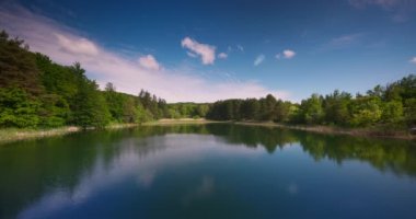 Nature landscape of mountain lake and forest in morning light reflected in calm waters of pond, 4K relaxation video 