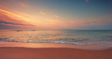 Color sunrise over ocean beach. Splashing sea waves on the coast sand, 4K video of seascape view