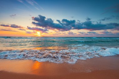Beautiful sunrise over the sea and beach. Summer morning and ocean waves. 