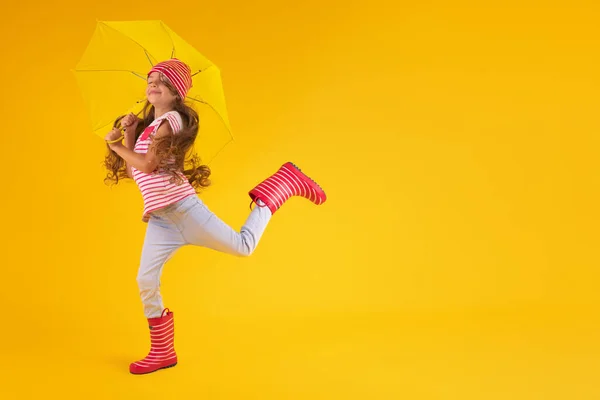 Mädchen Mit Gummistiefeln Für Regen Und Regenschirm Über Gelbem Hintergrund — Stockfoto