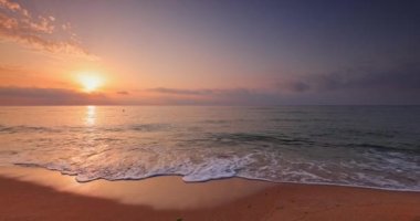 Okyanus kıyısında gün doğumu. Kuma su sıçratan deniz dalgaları, deniz manzaralı 4K video