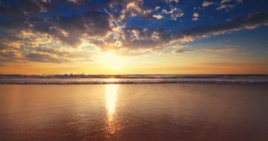 Altın okyanus sahili gün doğumu ve deniz kumu üzerine su sıçratan dalgalar, doğanın 4K videosu, okyanus tropikal deniz manzarası