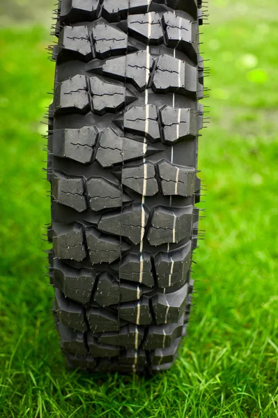 Tire at green grass — Stock Photo, Image