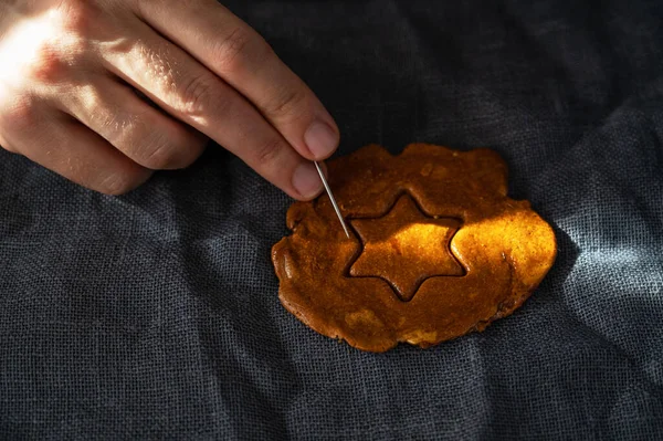 Mens mãos close-up arranhão e quebrar açúcar mascavo caramelo doces — Fotografia de Stock