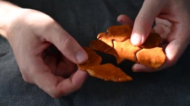 Erkekler el sıkışıyor. Yakın plan. Esmer şekerli karamel kırılıyor.