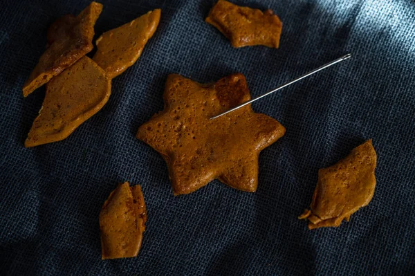 Kırık kahverengi şekerli karamelli kurabiyeler ve metal bir iğne. — Stok fotoğraf