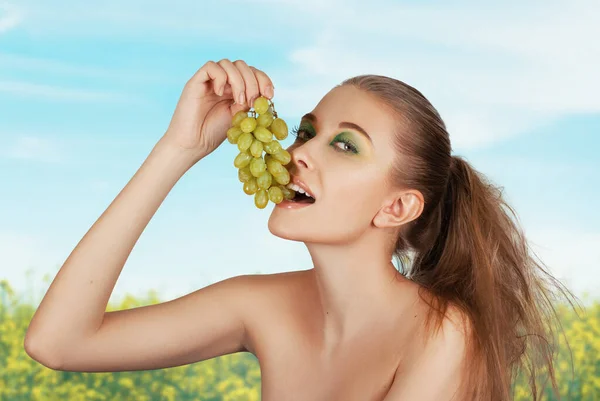 Beautiful young woman with grape bunches Royalty Free Stock Images