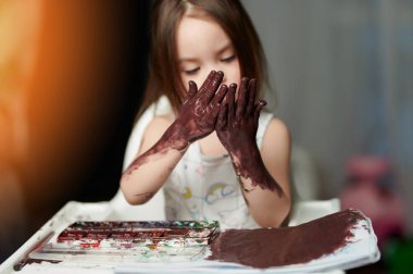 Ellerini boyayarak boyamış.