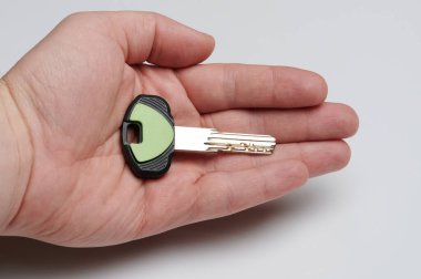 Yeni ev anahtarı avuçta. Yakın çekim görüntüsü izole edilmiş.