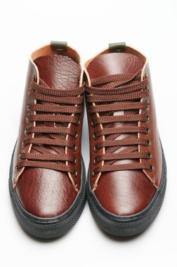 Stüdyonun arka planında izole edilmiş kahverengi deri ayakkabılar.