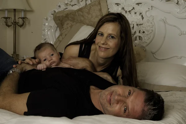 Familie liggend op bed — Stockfoto
