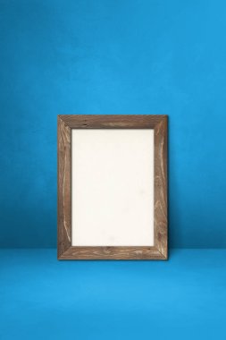 Mavi bir duvara yaslanmış ahşap çerçeve. Boş model şablonu