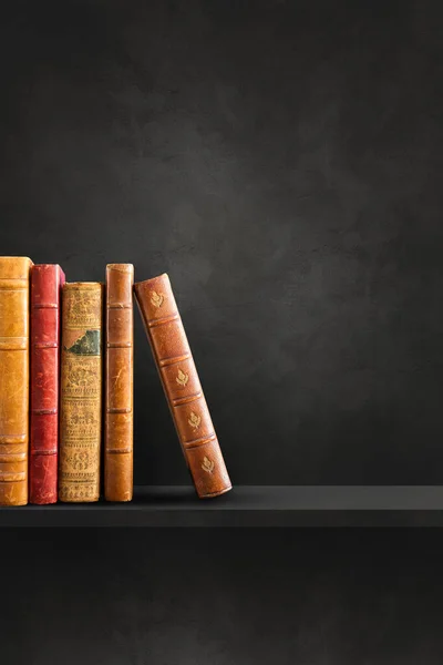 黒の棚に古い本の行 垂直背景シーン — ストック写真