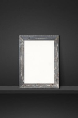 Siyah bir rafa yaslanmış ahşap çerçeve. 3 boyutlu illüstrasyon. Boş model şablonu. Dikey arkaplan