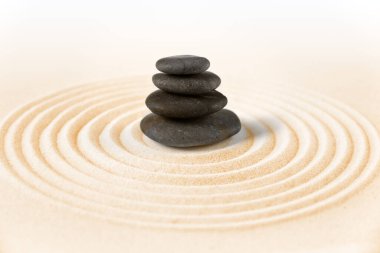 Siyah taşlar kuma yığılır. Zen Japon bahçe arka planı
