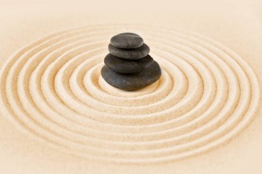Siyah taşlar kuma yığılır. Zen Japon bahçe arka planı