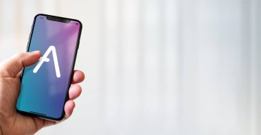 Paris - Fransa - 15 Mart 2022: AVE kripto para birimi logosuna sahip iPhone akıllı telefonu. Yatay Pankart