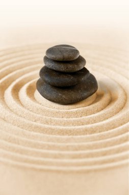 Siyah taşlar kuma yığılır. Zen Japon bahçe arka planı