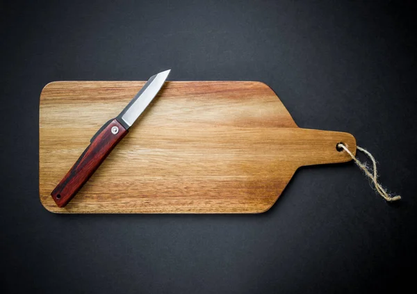 木製のまな板に伝統的な日本のヒゴノカミのポケットナイフ 黒の背景 — ストック写真