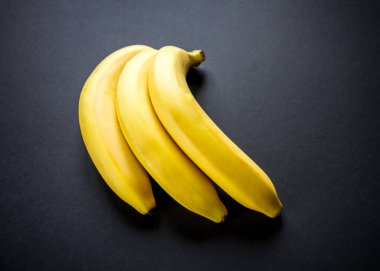 Siyah arka planda izole edilmiş bir grup taze muz.