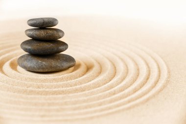 Siyah taşlar kuma yığılır. Zen Japon bahçe arka planı