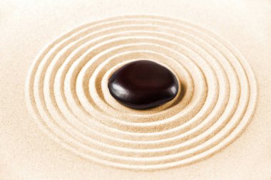 Kumda siyah bir taş. Zen Japon bahçe arka planı