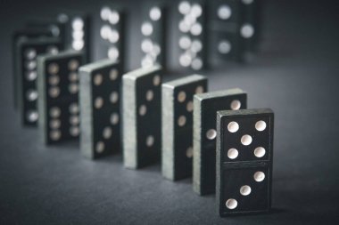 Arka planda siyah domino taşları zinciri. Domino etkisi kavramı