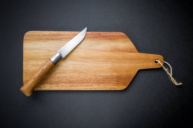 Geleneksel çakı, tahta kesme tahtasının üzerinde. Siyah arkaplan