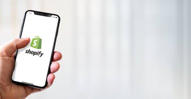 Paris - Fransa - 15 Mart 2022: Shopify logolu iPhone akıllı telefonu. Yatay Pankart