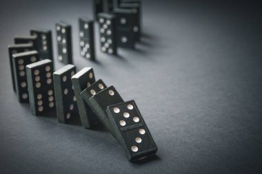 Arka planda siyah domino taşları zinciri. Domino etkisi kavramı