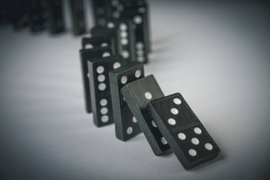 Arka planda siyah domino taşları zinciri. Domino etkisi kavramı