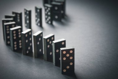 Arka planda siyah domino taşları zinciri. Domino etkisi kavramı