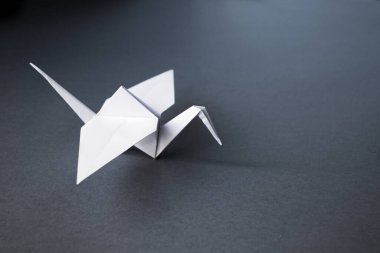 Beyaz kağıt turna origamisi boş gri bir arkaplanda izole edildi.