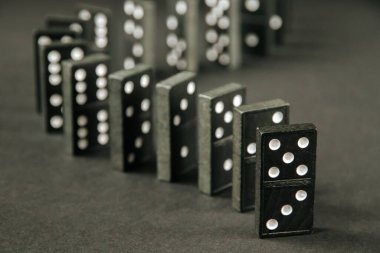 Arka planda siyah domino taşları zinciri. Domino etkisi kavramı