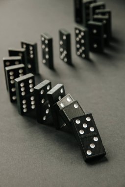 Arka planda siyah domino taşları zinciri. Domino etkisi kavramı