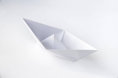 Kağıt tekne origamisi boş bir arkaplanda izole edildi.
