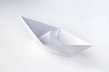 Kağıt tekne origamisi boş bir arkaplanda izole edildi.