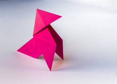 Pembe kağıt tavuk origamisi beyaz bir arkaplanda izole edilmiş. Cocotte en paper