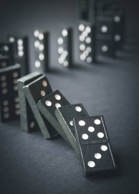 Arka planda siyah domino taşları zinciri. Domino etkisi kavramı
