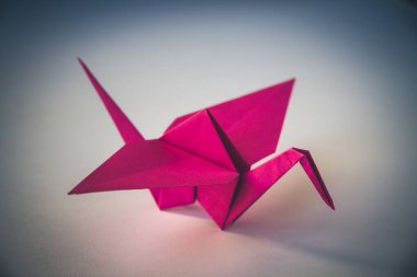 Pembe kağıt turna origamisi boş bir arkaplanda izole edildi.