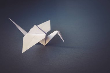 Beyaz kağıt turna origamisi boş gri bir arkaplanda izole edildi.