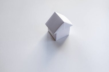 Kağıt ev origamisi boş beyaz bir arkaplanda izole edildi.