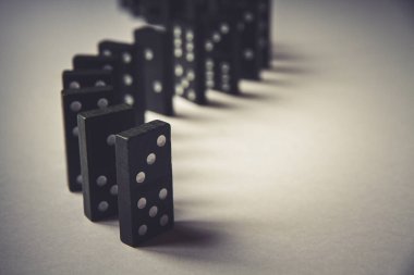 Arka planda siyah domino taşları zinciri. Domino etkisi kavramı